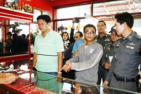 Bunliam Luechailam shows police and the press how he held up a gold shop. 