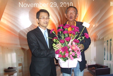 Poodis Poramapojn, director of finance (left) receives a congratulatory bouquet from Niti Kongkrut, director of the Tourism Authority of Thailand’s Pattaya office.