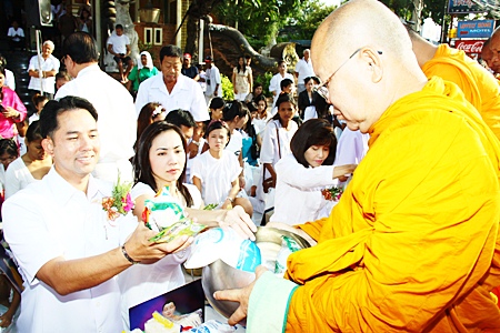 Mayor Itthipol Khumplome and his wife Rachada Chatikavanij enjoy making merit together by giving alms to the Buddhist monks.