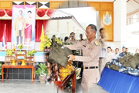 In front a portrait of Their Majesties the King and Queen, Rear Adm. Chainarong Kaowiset, Chief of Staff in Navy Region 1, presides over ceremonies to begin distribution of 400 bags of emergency supplies to flood victims in Chumphon. 