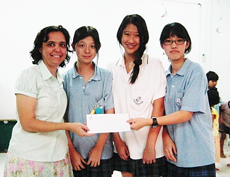 Margaret Grainger receives an 80,000 baht donation to the Hand to Hand center from ISE students.