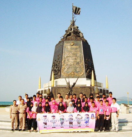 Rear Adm. Traikwan Krairuek and navy personnel pose with the children from the south in front of the Royal Thai Marines monument. 