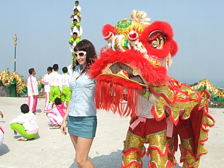 This lovely visitor poses for a commemorative photo with one of the lion dancers.