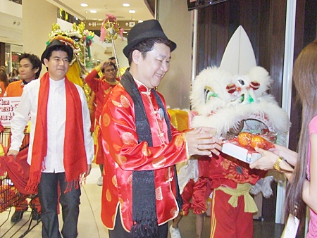 Saran Tantichamnan, GM of Central Festival Pattaya Beach, and his dragon and lion dance team visit shopkeepers to wish them a Happy New Year.