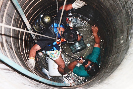 A rescue worker is lowered into the well to retrieve 15-year-old Kittipong. 