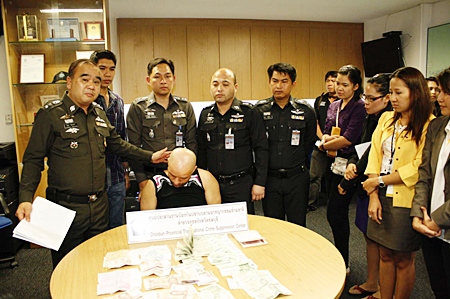 Paul Adrain Trica sits head bowed at Pattaya Police Station following his arrests on charges of theft from currency exchange booths.