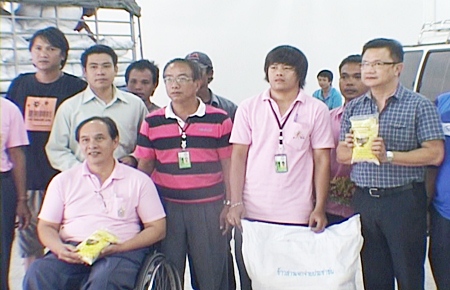 Deputy Mayor Wutisak Rermkitkarn, right, helps volunteers distribute rice to 19 orphanages, shelters and disabled centers in the Pattaya area.
