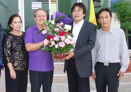 Deputy Mayor Ronakit Ekasing presents a bouquet to Prem and Supanee.