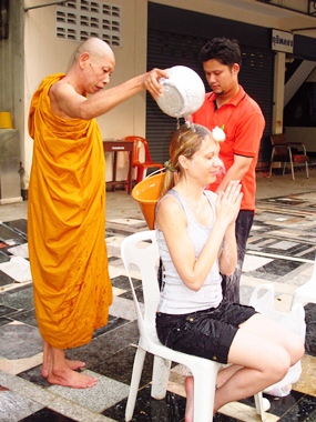 Thepprasit Temple’s Assistant Abbott Bunsong Jantimo pours holy water over Kristina to turn bad luck to good. 
