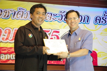 Visal Saengjaroen (left) of Channel 7 receives his plaque for the best photographer in biographical news from Chonburi Vice Governor Pongsak Preechawit.