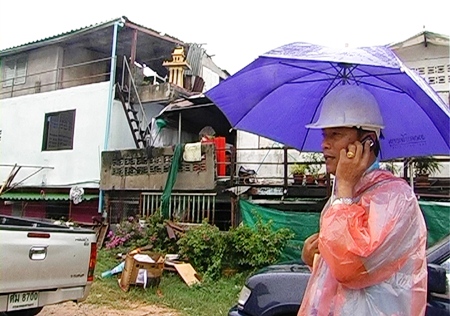 A city official inspects property in South Pattaya for signs storm damage.