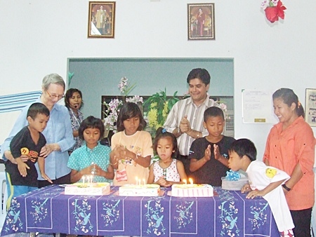 Sister Joan and Tony cheer as the birthday children blow out the candles on the birthday cakes. 
