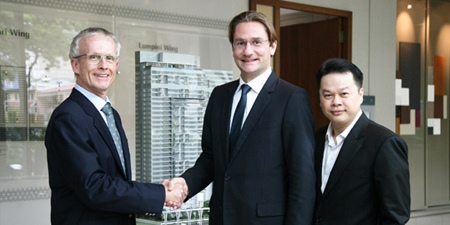 Bouygues Thai Managing Director Jean-Marie Verbrugghe, left, shakes hands with Raimon Land’s Chief Executive Officer Hubert Viriot, center, as Raimon Land Chief Operating Officer Kitti TungSriwong looks on. 