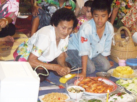 Naklua residents, young and old, prepare food and desserts for the spirits.