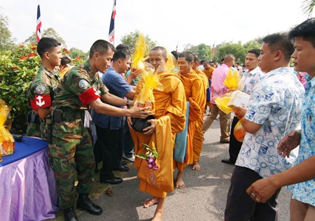 Enlisted men and officers present offerings of rice, dried food and other items to monks from Rangsri Sunthorn Temple.