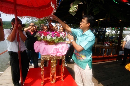 Rear Adm. Tharathorn Kachitsuwan sprinkles water on the Buddha to make merit during the traditional Songkran ceremony. 