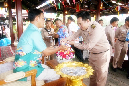 Officers and enlisted men perform the Rod Nam Dam Hua, pouring water over the hands of Rear Adm. Tharathorn Kachitsuwan, Air and Coastal Defense commander.