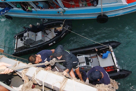Tourists are hoisted aboard the HTMS Chakri Naruebet just off the coast of Koh Tao.