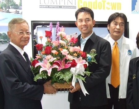 Pakorn Thavisin, left, Chairman LPN Development Public Company Ltd., receives a bouquet of flowerers from Pattaya Mayor Ithiphol Khunpluem congratulating him on the launch of the project.