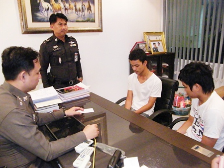 Thanawat Pornjit-udom and Pirapong Boonkor turn themselves in at Pattaya Police Station. 