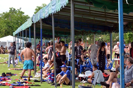 Players and spectators take some welcome shelter from the hot sun.