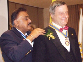 PDG Peter Malhotra presents the chain of office to President Yves Echement of the Rotary Club of Pattaya Marina.
