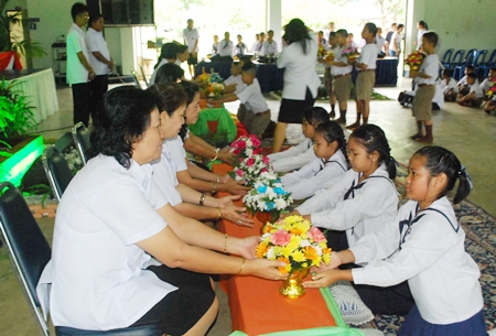 The students present trays of flowers, incense and candles to their teachers.