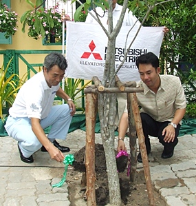 Hidetoshi Kan (left), managing director of Mitsubishi Elevator Thailand Co., Ltd., and Mayor Itthiphol Kunplome plant a tree to mark the 88th anniversary of Pattaya School #8. 