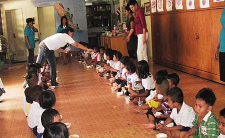 The young students dutifully line up to eat and enjoy the delicious snacks provided by the Human Resources team from Sheraton Pattaya Resort.