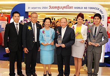 Chatchawal Supachayanont (3rd right), general manager of Dusit Thani Pattaya holds up the award from the WHO. He is joined by the Secretary of Action on Smoking and Health Foundation, Prof. Dr. Prakit Vathesatogkit (2nd left) and his family. Two of the awardees Koong Suthirach (right) and Poy Pornwara (2nd right), both from the entertainment industry are also seen in the picture after the conclusion of the World No-Tobacco Day 2011 celebration held in Bangkok. 