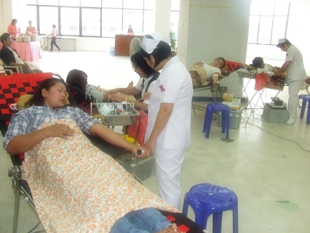 Employees and customers at Mike Shopping Mall roll up their sleeves to donate blood to the Thai Red Cross. 