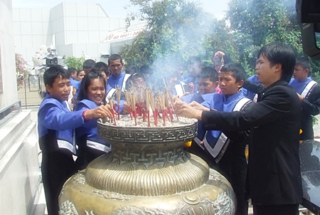 The young band members join in the ceremony by lighting and placing joss sticks in the ceremonial urn in front of City Hall.