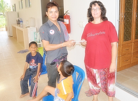 Loi (left), head of Jutamat Beauty School in Soi 16, Pattaya South, donates nearly 700 baht to Sharon Greenhalgh, who is in charge of the Mercy Children’s Home, to help with the cost of continuing construction.