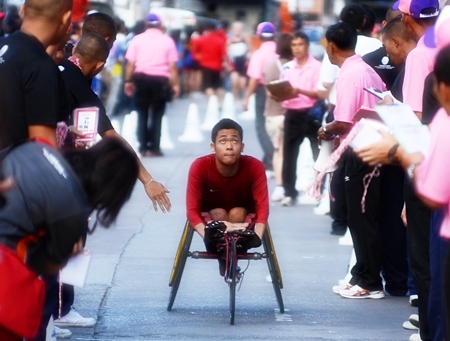 A wheelchair athlete checks his time as he crosses the finish line.