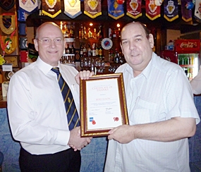 Graham Macdonald, president of the Royal British Legion Thailand presents a certificate of thanks to Bert Elson for the welfare work carried out in Thailand.