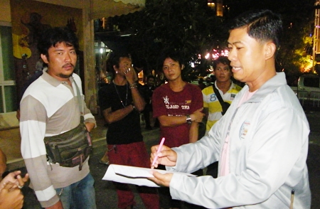 Krit Suwanpiyawong (left) is taken into custody by Maj. Wasu Sangsuksai (right), chief of Pattaya City Hall’s regulatory enforcement department. 