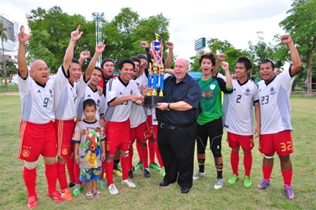 The winning Siam Sport Deutscher Fußball Fanklub team receive the trophy from Reiner “Calli” Calmund.