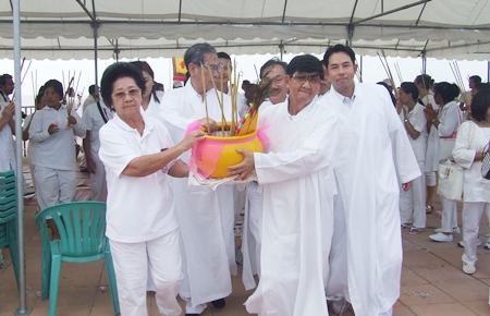Leaders carry the ceremonial incense pot into the holy ground to pay respects to their deity.