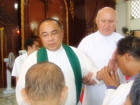 Father Corsie Legaspi lays his healing hands on the congregation.
