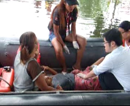 Doctors and emergency medical technicians help Rattana Thassanawadee deliver a baby boy aboard a rubber raft amidst all the flooding. 