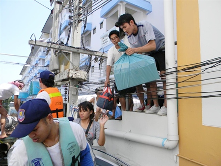 Members of the Sawang Boriboon Foundation evacuate people from upper floors in Nava Nakorn. 