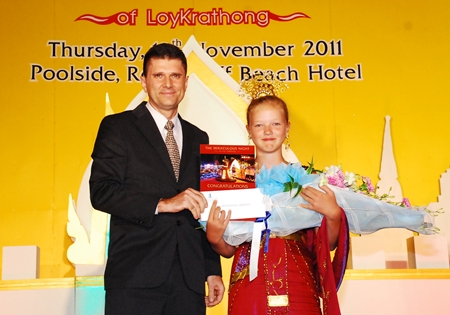 Royal Cliff Hotels Group General Manager Joachim Grill presents Miss Liza from Russia with the award for winning the Best Traditional Dressed Guest competition at the Royal Cliff Beach Hotel.