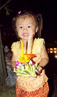 A future Nang Noppamas contestant prepares to loy her krathong at the Pattaya Floating Market.