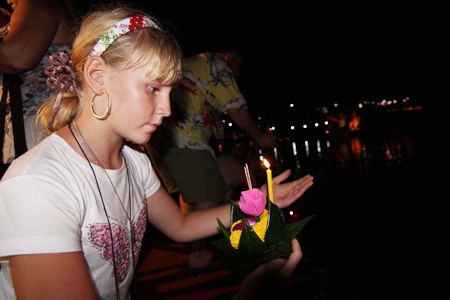 A young woman from Russia makes wish before setting her krathong afloat at Nong Nooch Tropical Garden.