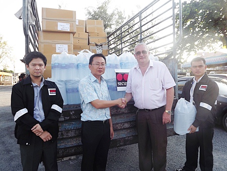 Securitas country manager, Steve Graham (2nd right) presents water and supplies to Sawang Boriboon Vice President Sinchai Wattanasartsathorn (2nd left). 