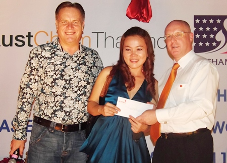 Simon Matthews (left) joins newly elected chairman of the BCCT Eastern seaboard and Amari GM David Cumming (right) in presenting a raffle prize to Anongrat (Som) Corness of Siam Country Club Beauty Supplies. 