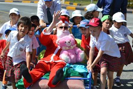 Key stage 1 students pulling Santa around the oval.