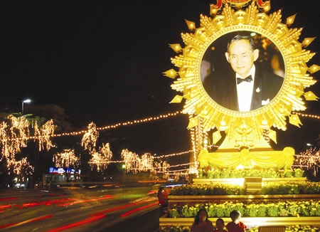 Tail lights from passing vehicles form streaks by a giant portait of His Majesty the King in Bangkok Thursday, Dec. 5, 2002.