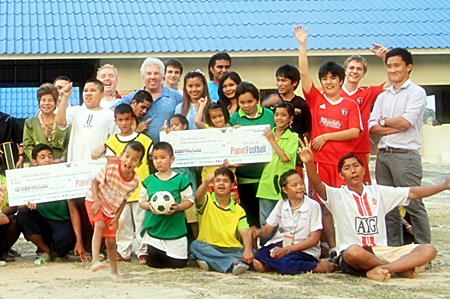 Martin Kinsella from Planet Football presents the children from Ban Si Ban Keow with a cheque for 120,000 baht.