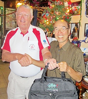 Dick Warberg (left) presents the MBMG Golfer of the Month award to Mashi Kaneta.